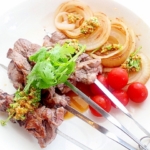 パクチーの特製タレで食べるラム肉の串焼き